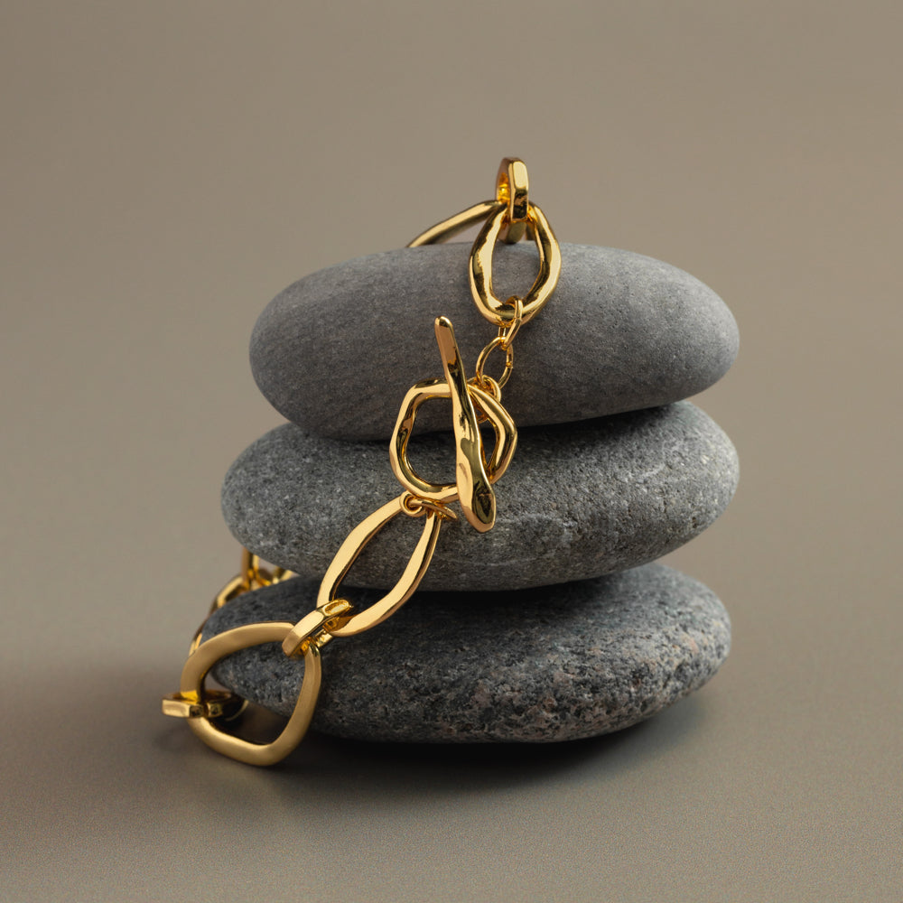Oval link bracelet draped over stacked stones