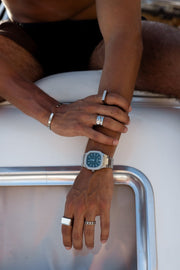 Arms resting on a white boat, watch on the wrist