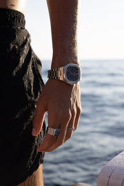 Hand by the sea wearing the watch