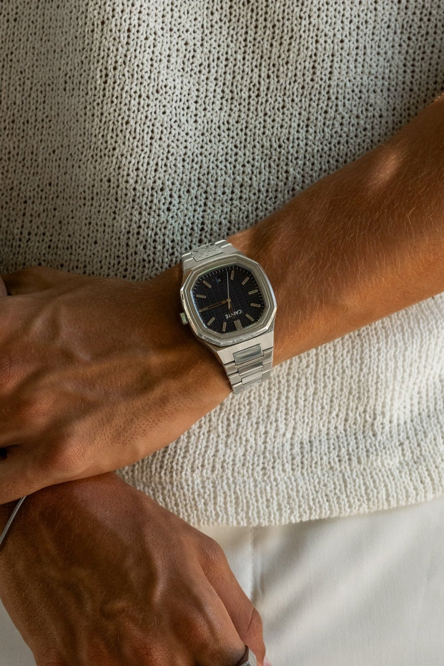 Watch on a wrist against a knit sweater
