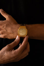 Hand adjusting the watch over a black shirt