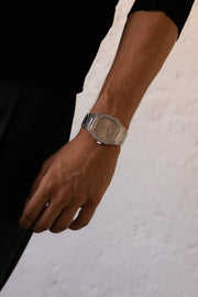 Arm hanging by the side wearing the watch