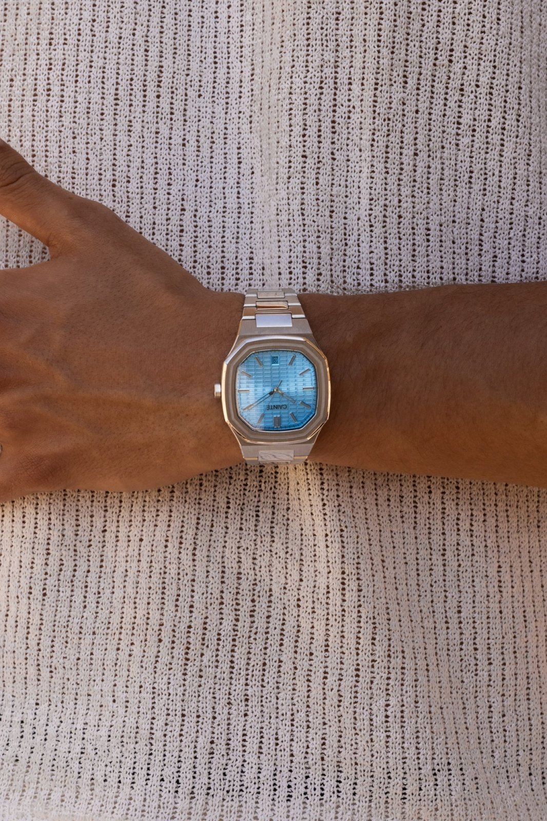 Watch on a wrist against a knit sweater