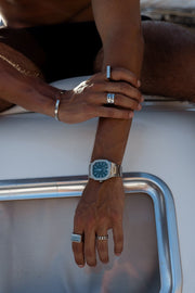 Arms resting on a white boat, watch on the wrist