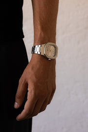 Wrist by a white wall wearing the watch
