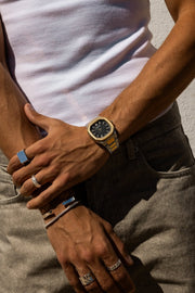Hands crossed over gray jeans, watch on the wrist