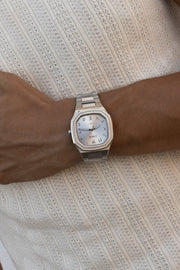 Watch on a wrist against a ribbed knit top