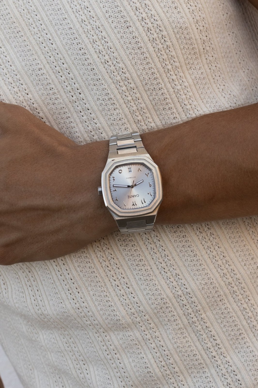 Watch on a wrist against a ribbed knit top