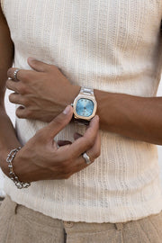 Hand adjusting the watch over a ribbed knit tank