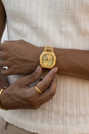Hand adjusting the watch over a ribbed knit tank