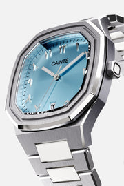 Three-quarter view of the octagonal case and turquoise Arabic numeral dial