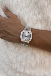 Watch on a wrist against a ribbed knit top