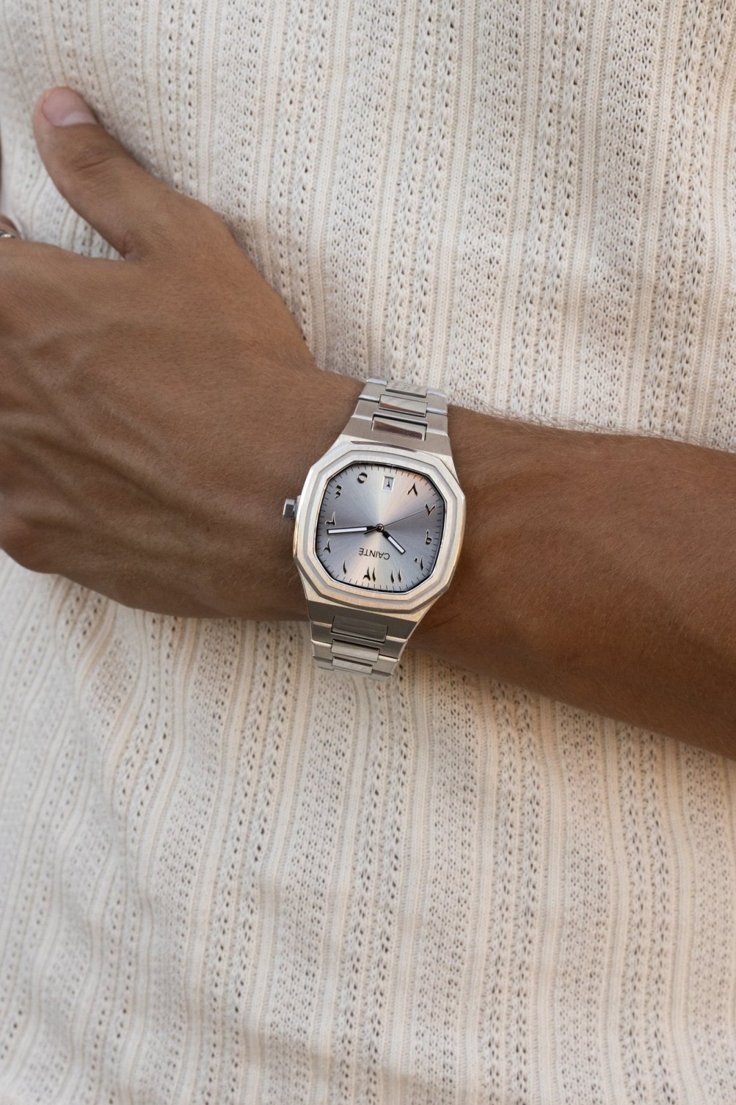 Watch on a wrist against a ribbed knit top