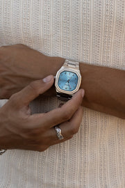 Hand adjusting the watch over a ribbed knit tank