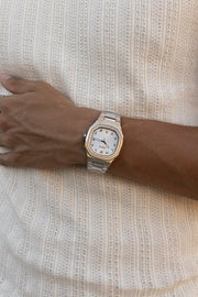 Watch on a wrist against a ribbed knit top