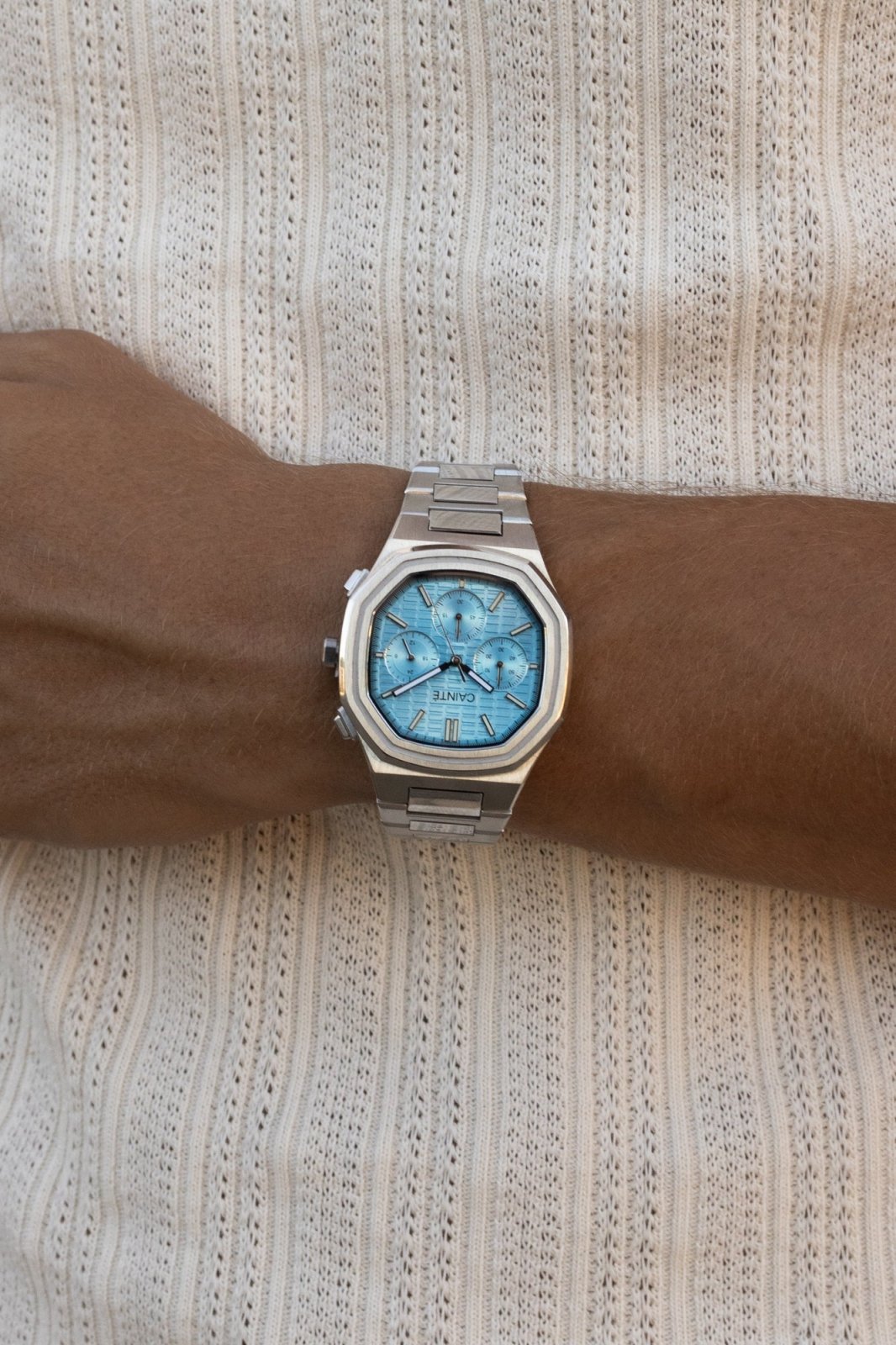 Watch on a wrist against a ribbed knit top