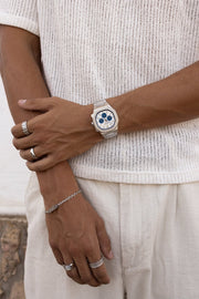 Arms crossed over a knit top, watch on the wrist
