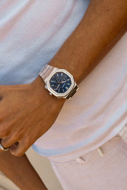 Watch on a wrist against a white T-shirt