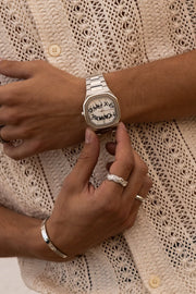 Hands adjusting the watch over a crochet shirt