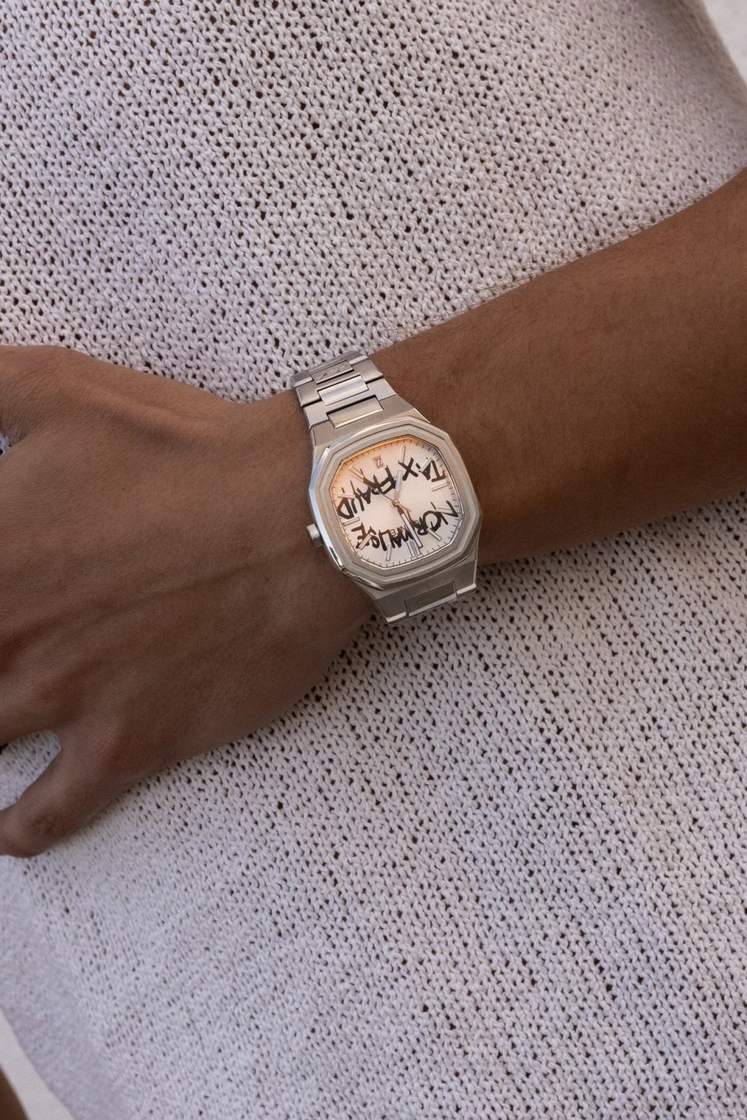 Watch on a wrist against a knit sweater