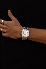 Watch on a wrist against a black top