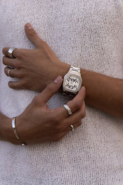 Hands adjusting the watch over a knit top