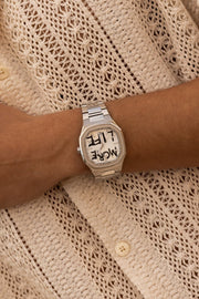 Watch on a wrist against a crochet shirt