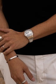Arms crossed over a black top with the watch