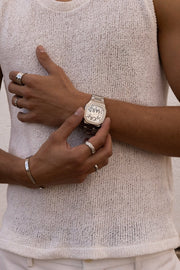Hands adjusting the watch over a knit top