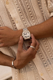 Fingers on the watch against a crochet shirt