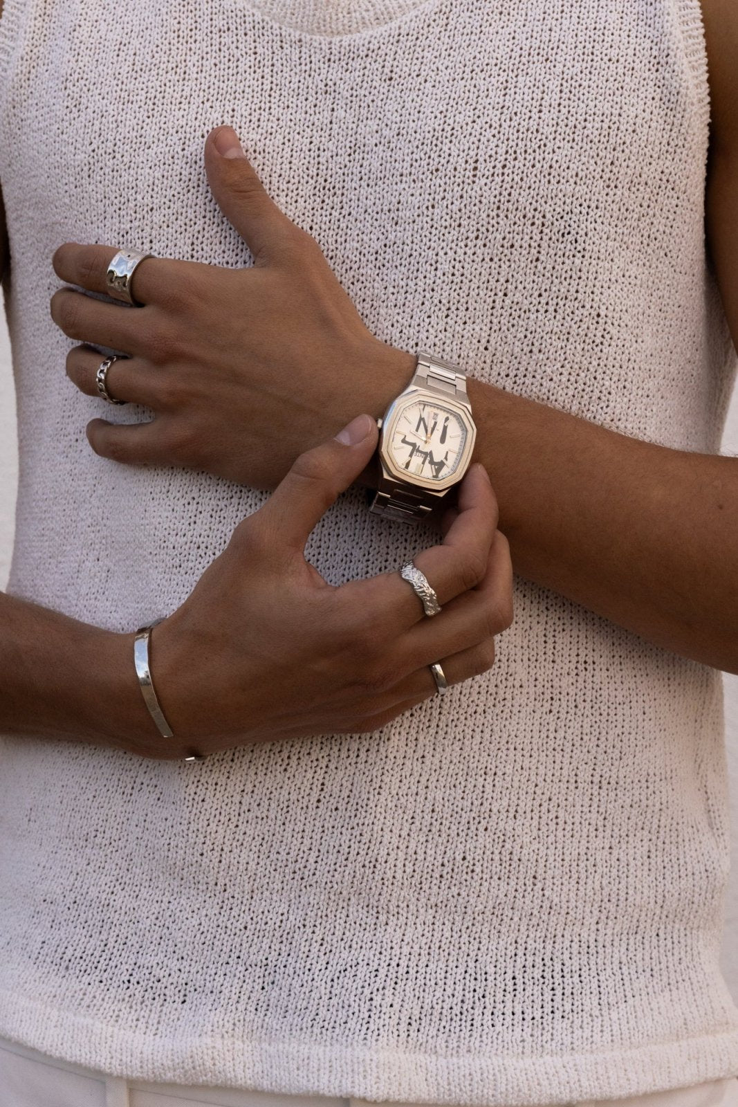 Hands adjusting the watch over a knit top