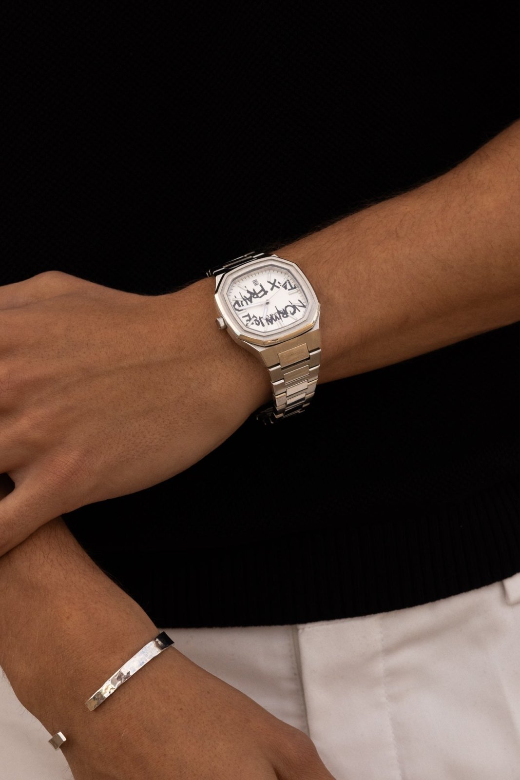 Arms crossed over a black top with the watch