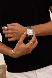 Fingers on the watch against a black top