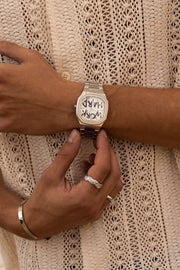 Hands adjusting the watch over a crochet shirt