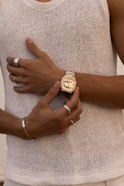 Hands adjusting the watch over a knit top