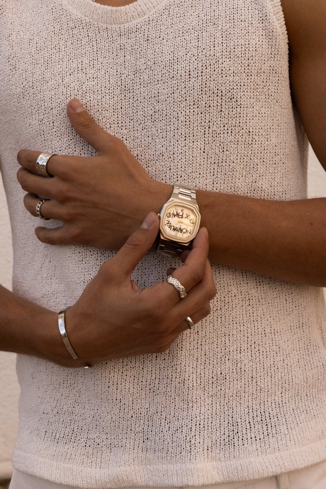 Hands adjusting the watch over a knit top