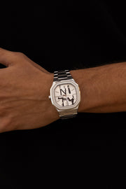 Watch on a wrist against a black top