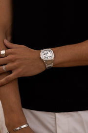 Arms crossed over a black top with the watch