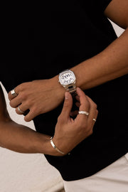 Close view of the watch being adjusted against black