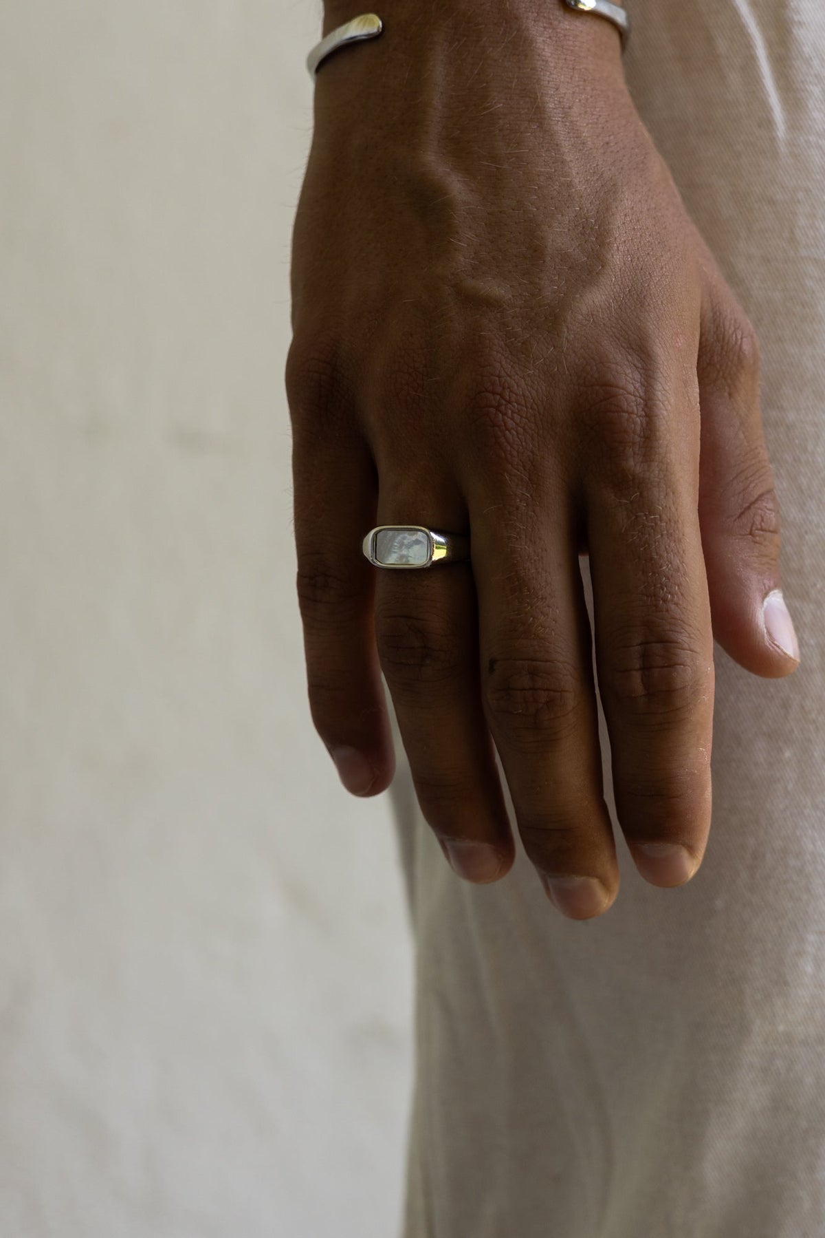 Close-up of the iridescent signet ring on the hand