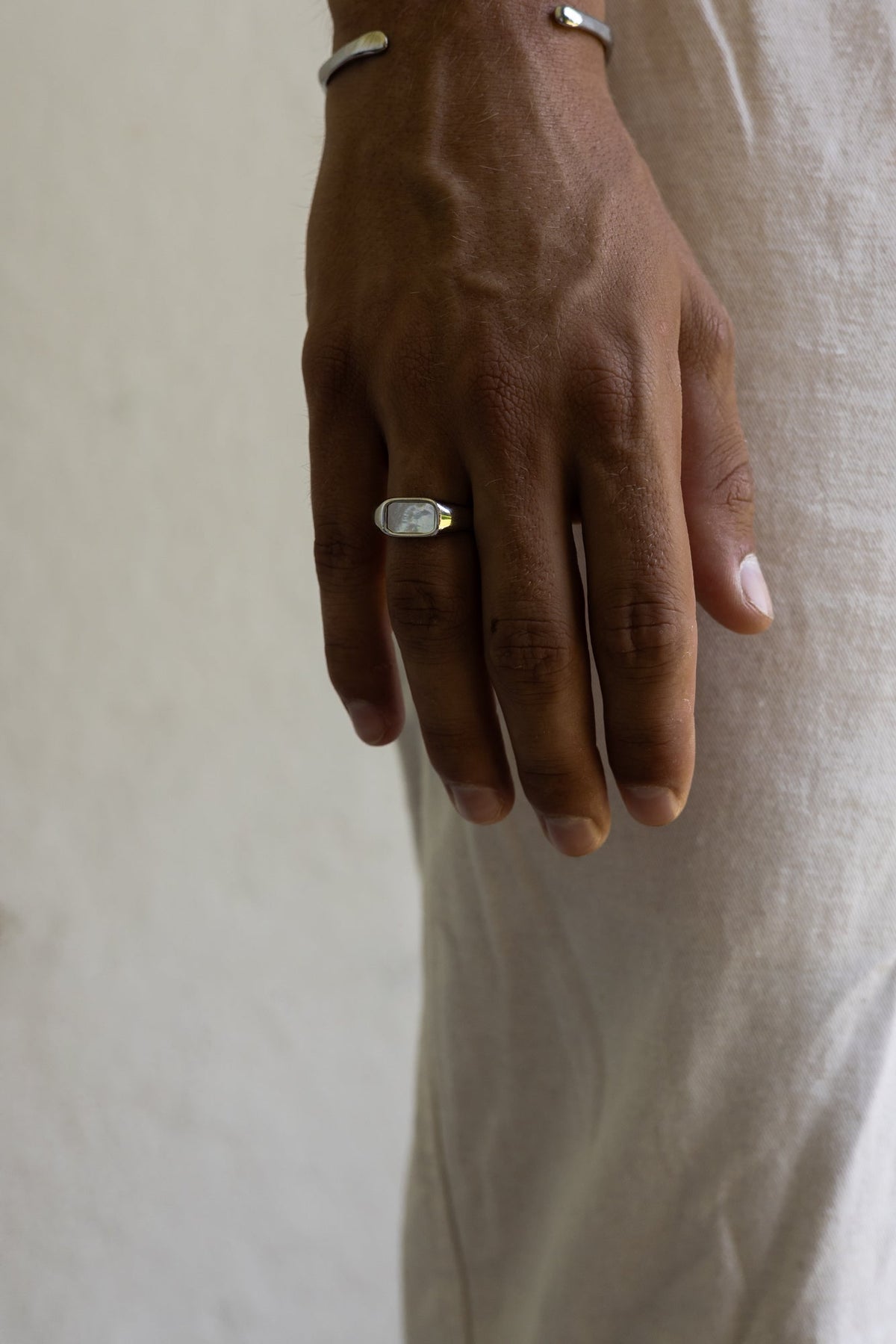 Hand at rest wearing the white inlay signet ring