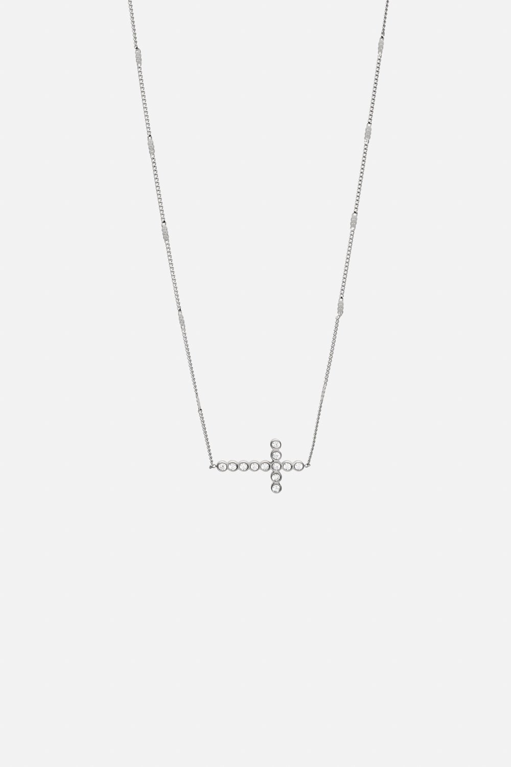 Silver-tone sideways cross necklace, front view on a light background
