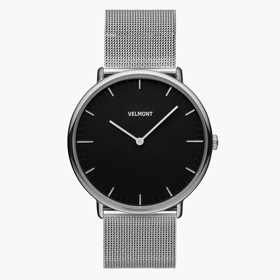 A black dial framed by a slim silver-tone case, set on a silver-tone mesh strap.