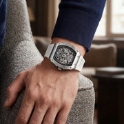 Skeleton watch with white strap worn on the wrist
