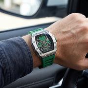 Green skeleton watch on the wrist in a car