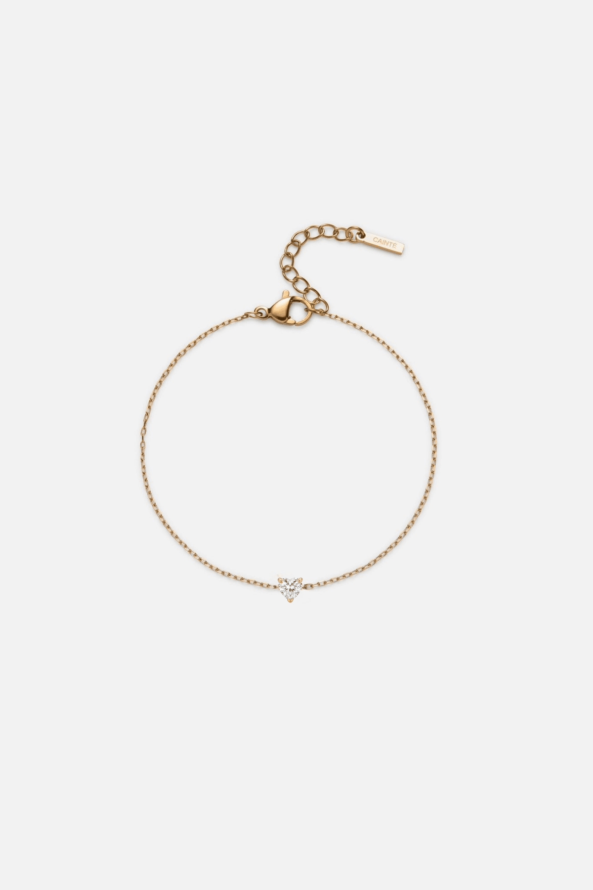 Gold-tone heart bracelet with a tiny stone, front view on a light background