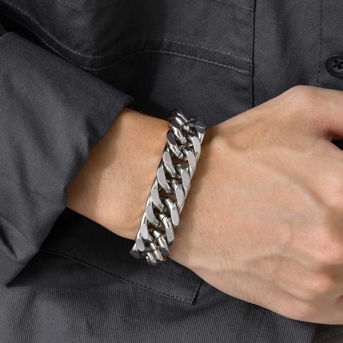 Silver-tone double curb chain bracelet on a wrist