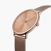 Watch turned at an angle, rose gold-tone sunburst dial and rose gold-tone bezel catching the light.