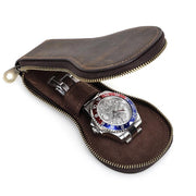 Open brown travel watch case with a watch inside