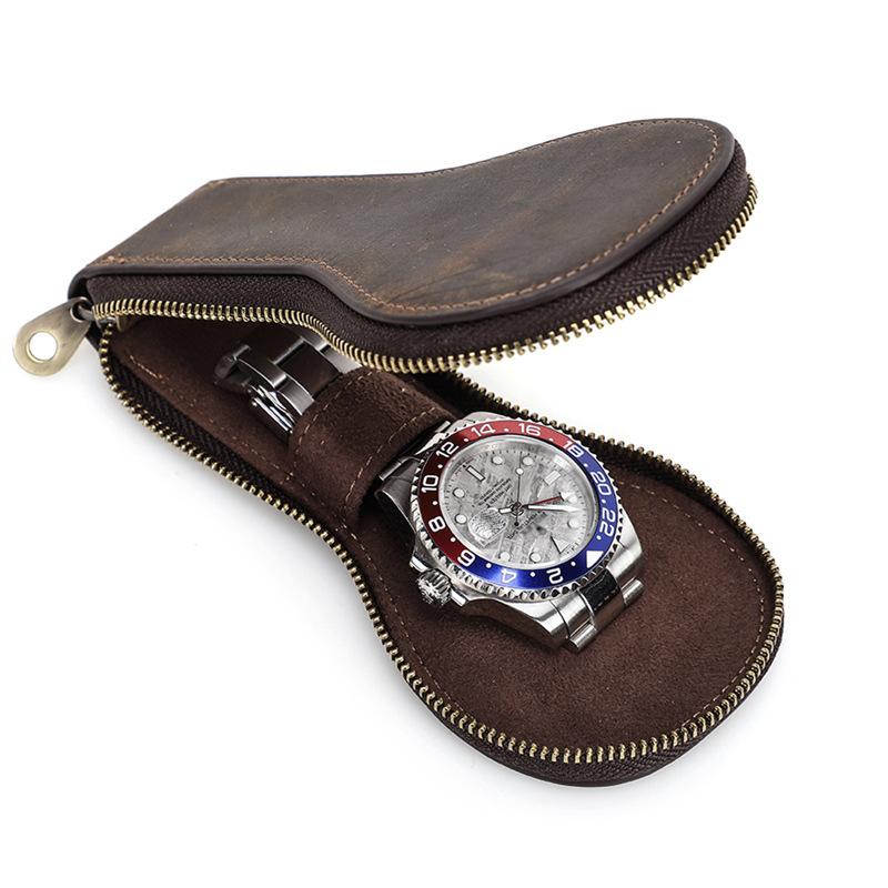 Open brown travel watch case with a watch inside